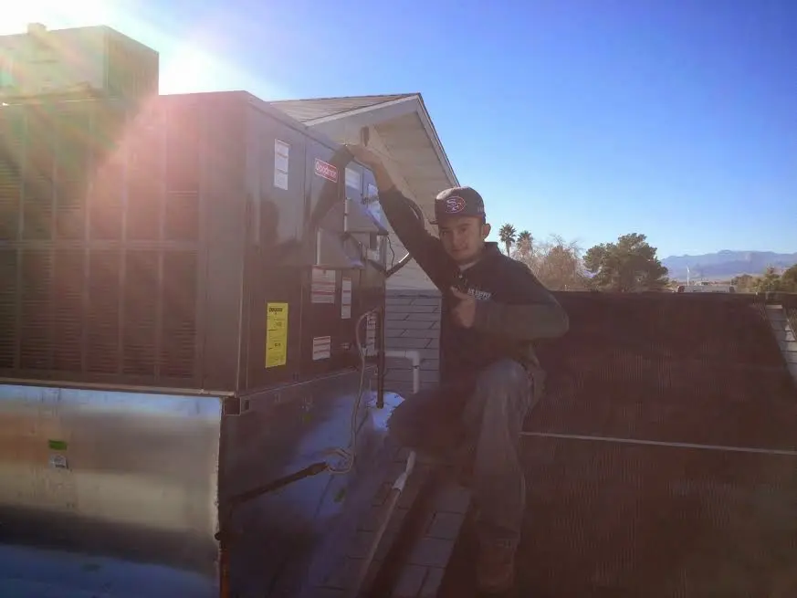 HVAC technician performing HVAC Inspection on a rooftop unit in South Lyon